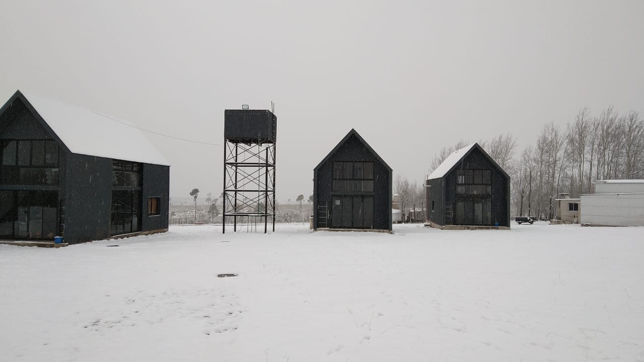 Cabañas Leon nevadas junto al tanque de agua