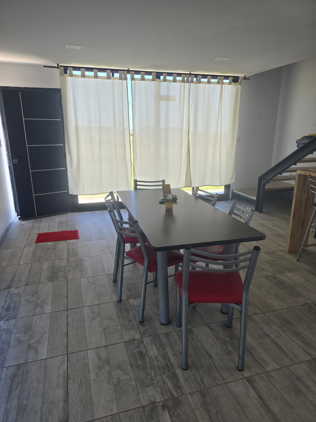 Sector de comedor de una cabaña con mesa, sillas y luz natural