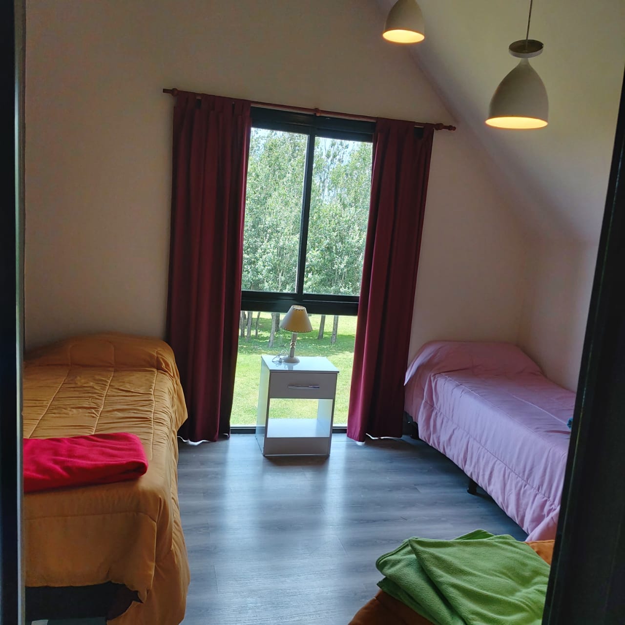 Dormitorio con dos camas individuales y vista al parque