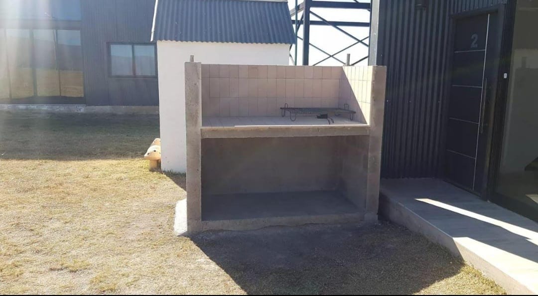 Asador de obra individual junto a una de las cabañas